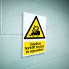 CA-FORK-PORT-001-07-BLOCK-WALL-WM-1.jpg Caution Forklift Trucks in Operation Sign - Active MHE Warning | A5, A4, A3 | Easi-Signs